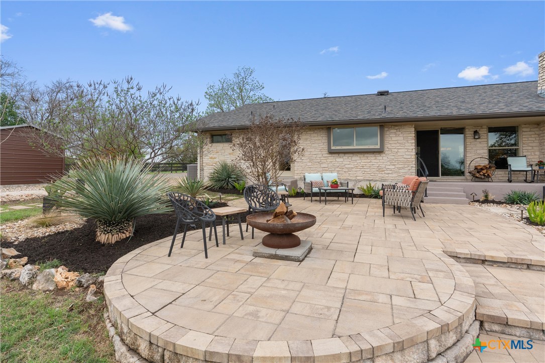 404 Skyline Road Georgetown, TX 78628 - Photo 26 of 40 a view of a backyard with table and chairs potted plants and a fountain
