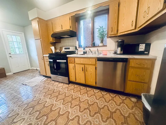 a kitchen with stainless steel appliances granite countertop a sink stove and cabinets