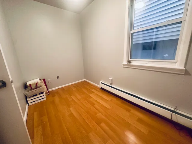 a blue bed sitting in a window next to a chair