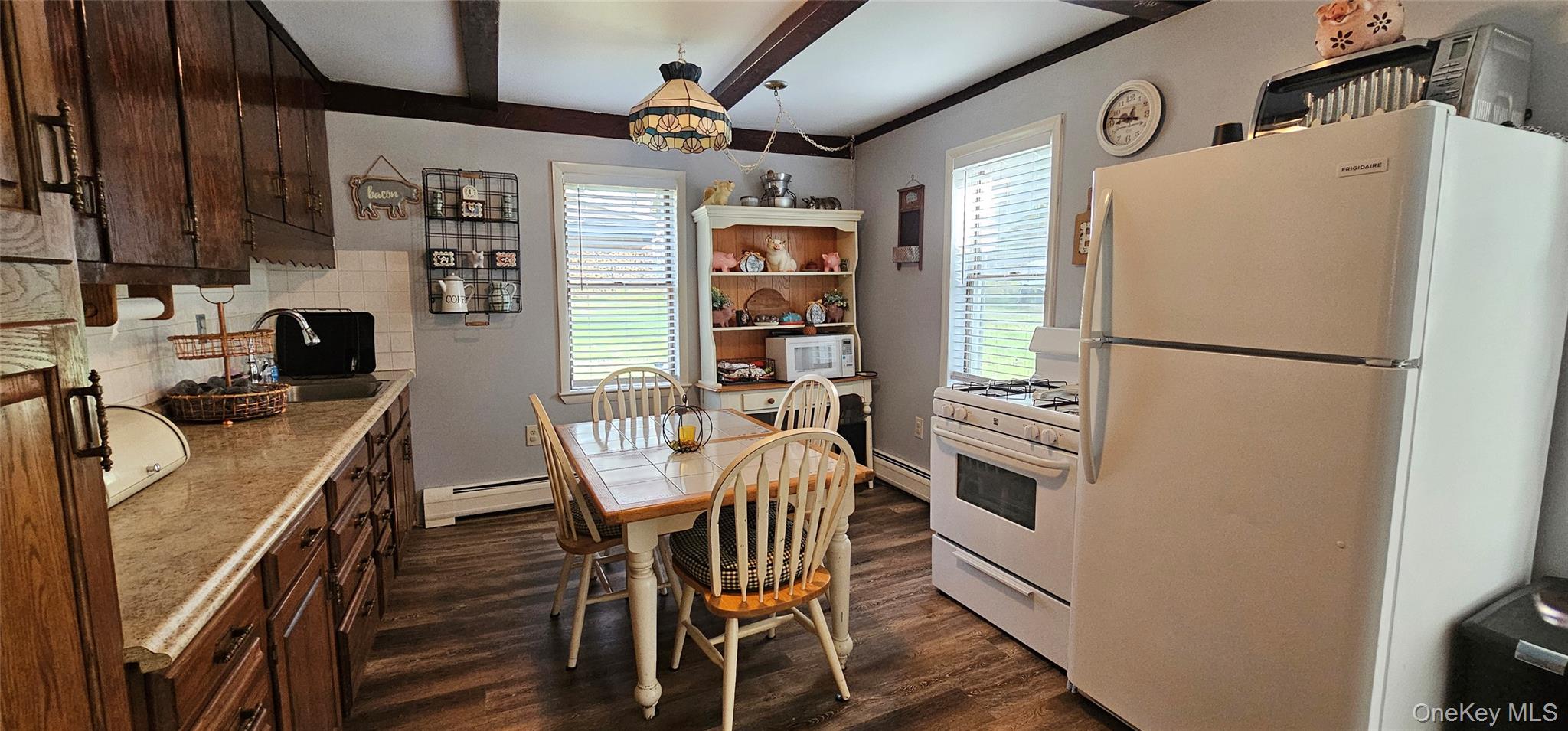 87 Parker Road Narrowsburg, NY 12764 - Photo 11 of 23 a kitchen with stainless steel appliances a refrigerator a stove a sink a dining table and chairs with wooden floor