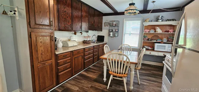 a kitchen with stainless steel appliances kitchen island granite countertop a refrigerator a stove a sink and a dining table with garden view