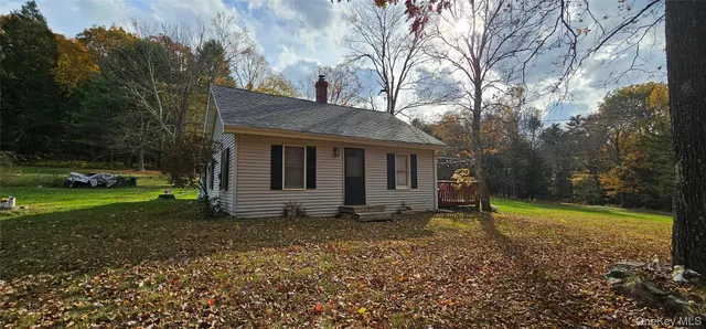 a view of a house with backyard and trees