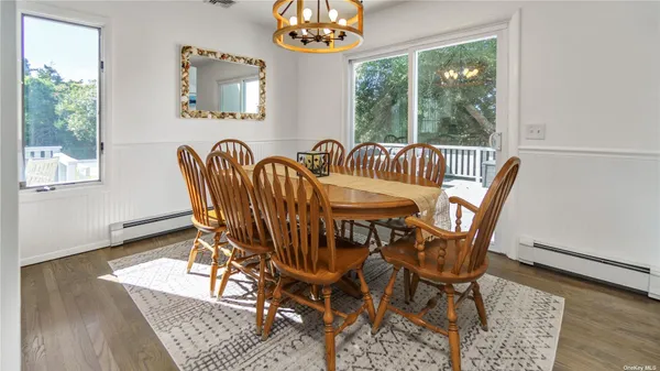 a view of a dining room with furniture a chandelier and wooden floor
