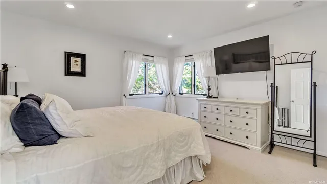 a bed room with a bed a television and a large window