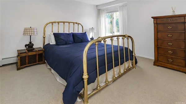 a bedroom with a bed a dresser and a window