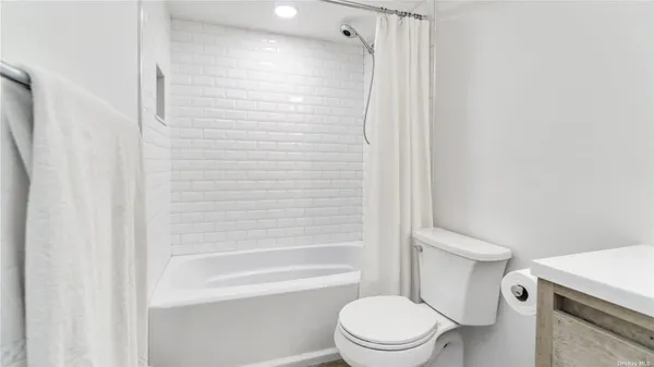a white toilet sitting next to a bath tub