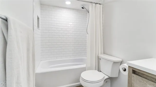 a white toilet sitting next to a bath tub