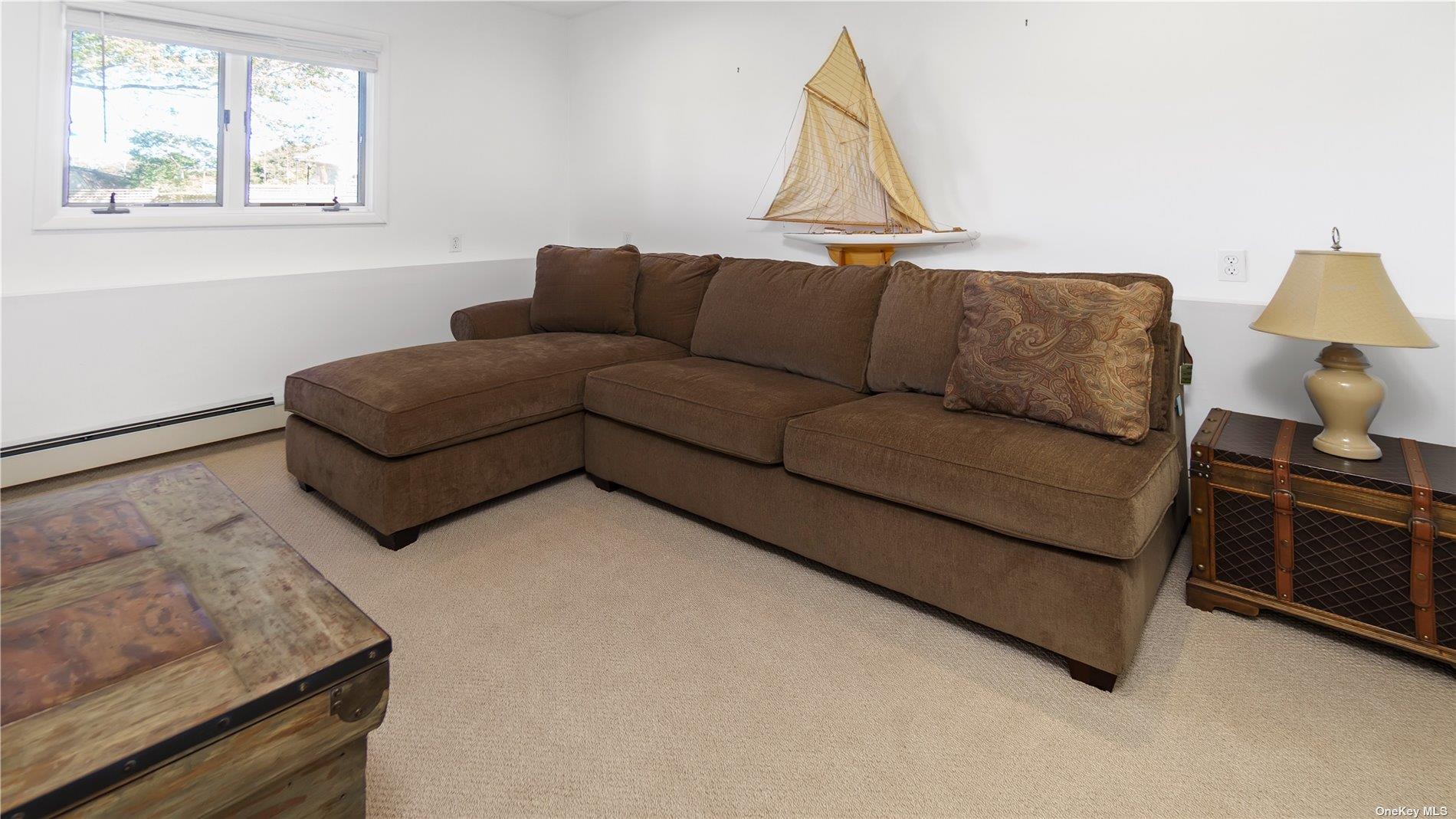 19 Rogers Lane Remsenburg, NY 11960 - Photo 18 of 28 a living room with furniture a flat screen tv and a window