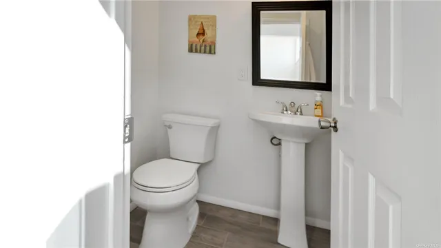 a bathroom with a toilet sink and mirror