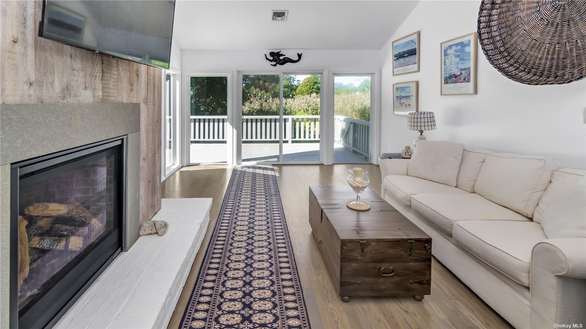 19 Rogers Lane Remsenburg, NY 11960 - Photo 6 of 28 a living room with furniture and a fireplace