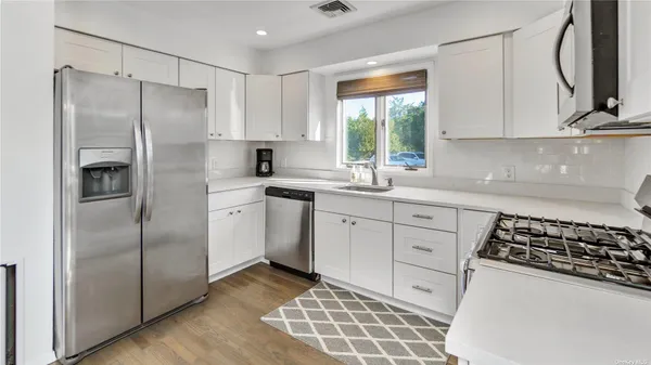 a kitchen with a refrigerator sink and cabinets