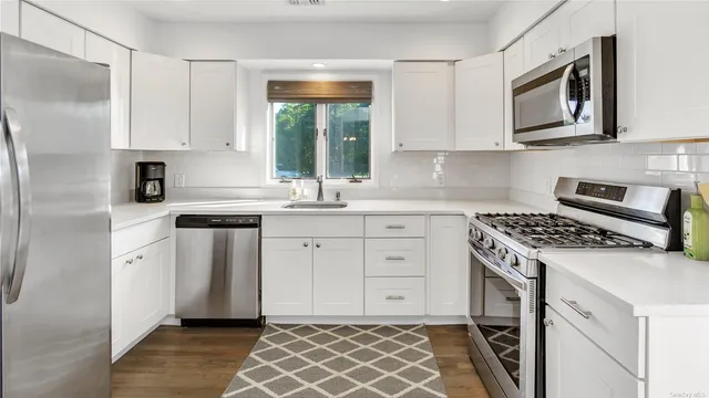 a kitchen with white cabinets stainless steel appliances and sink
