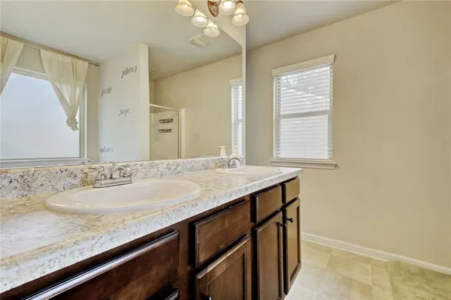 a bathroom with a granite countertop sink a large mirror and a window