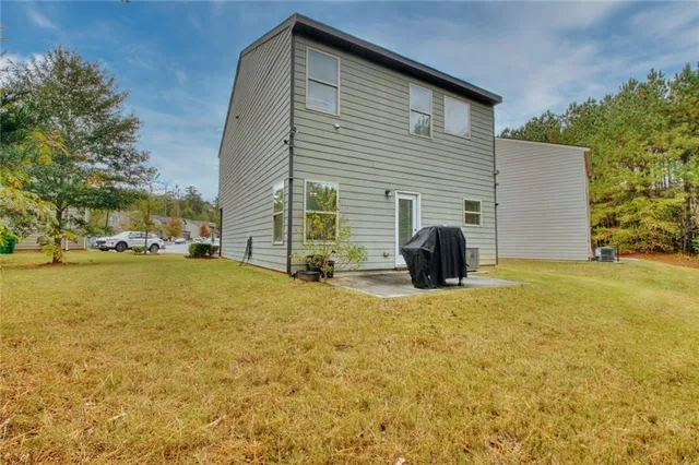 a view of a house with backyard and parking area