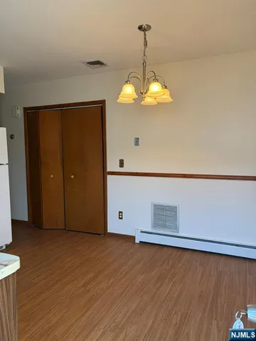 a view of a room with wooden floor and chandelier