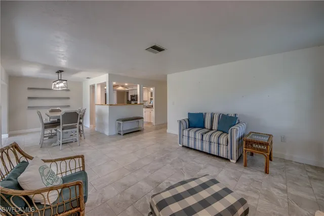 a living room with furniture and a dining table with rug