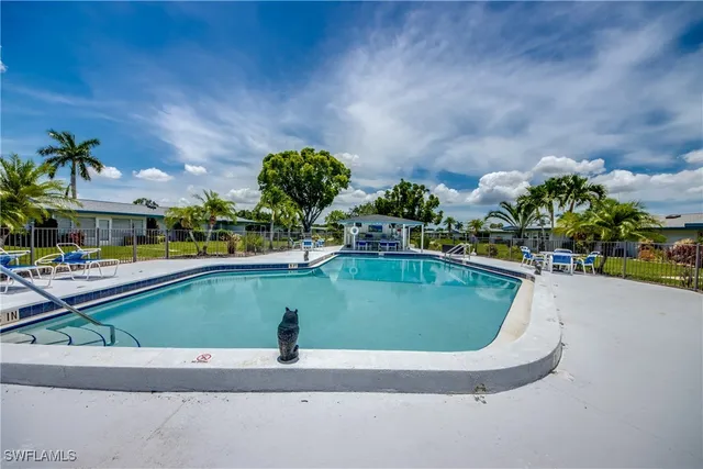 a view of swimming pool with outdoor seating and a garden