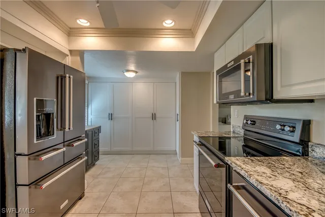 a kitchen with kitchen island granite countertop a stove refrigerator and cabinets