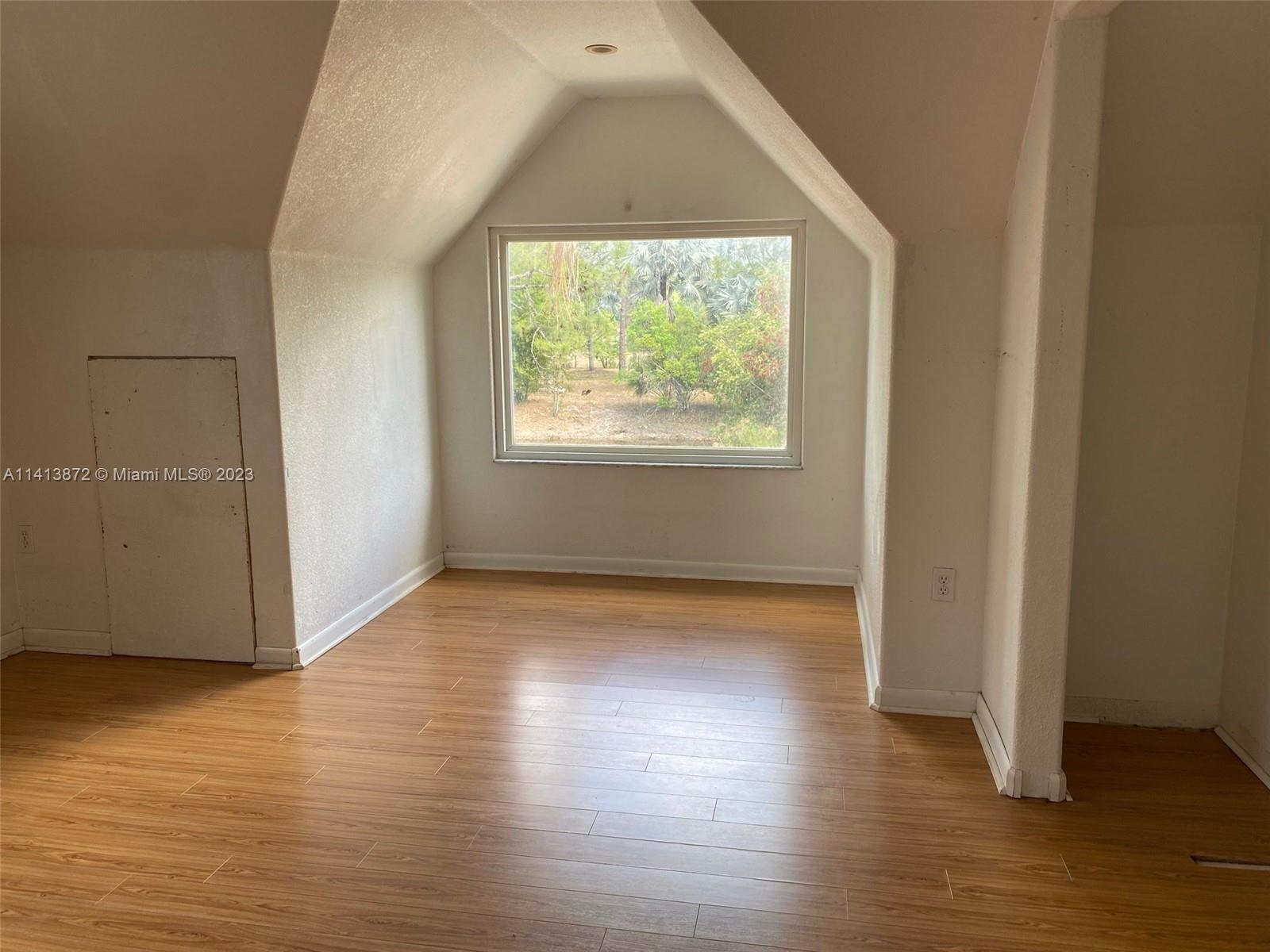 3141 C Road Loxahatchee, FL 33470 - Photo 13 of 16 an empty room with wooden floor and windows