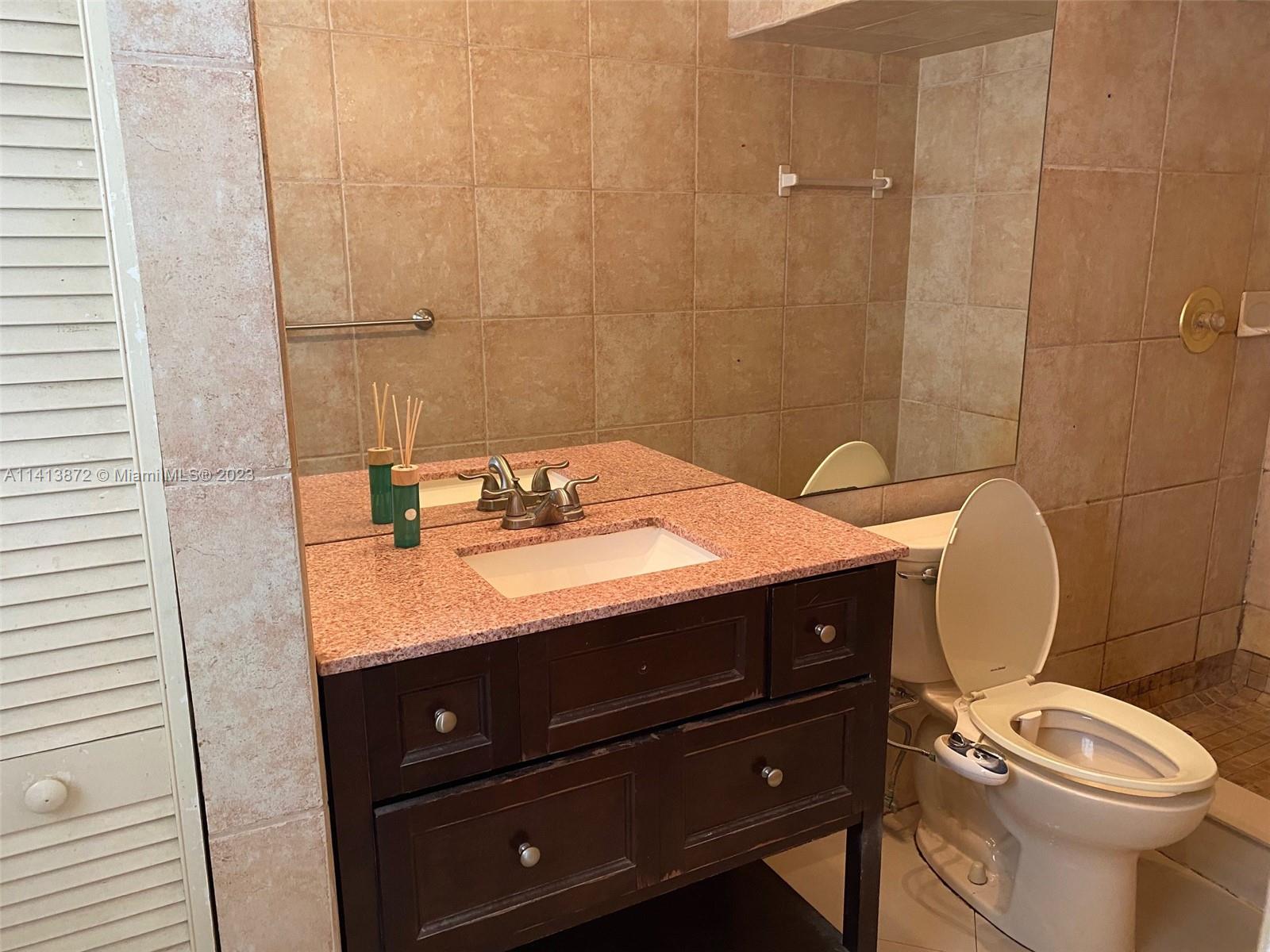 3141 C Road Loxahatchee, FL 33470 - Photo 14 of 16 a bathroom with a sink a toilet and a mirror