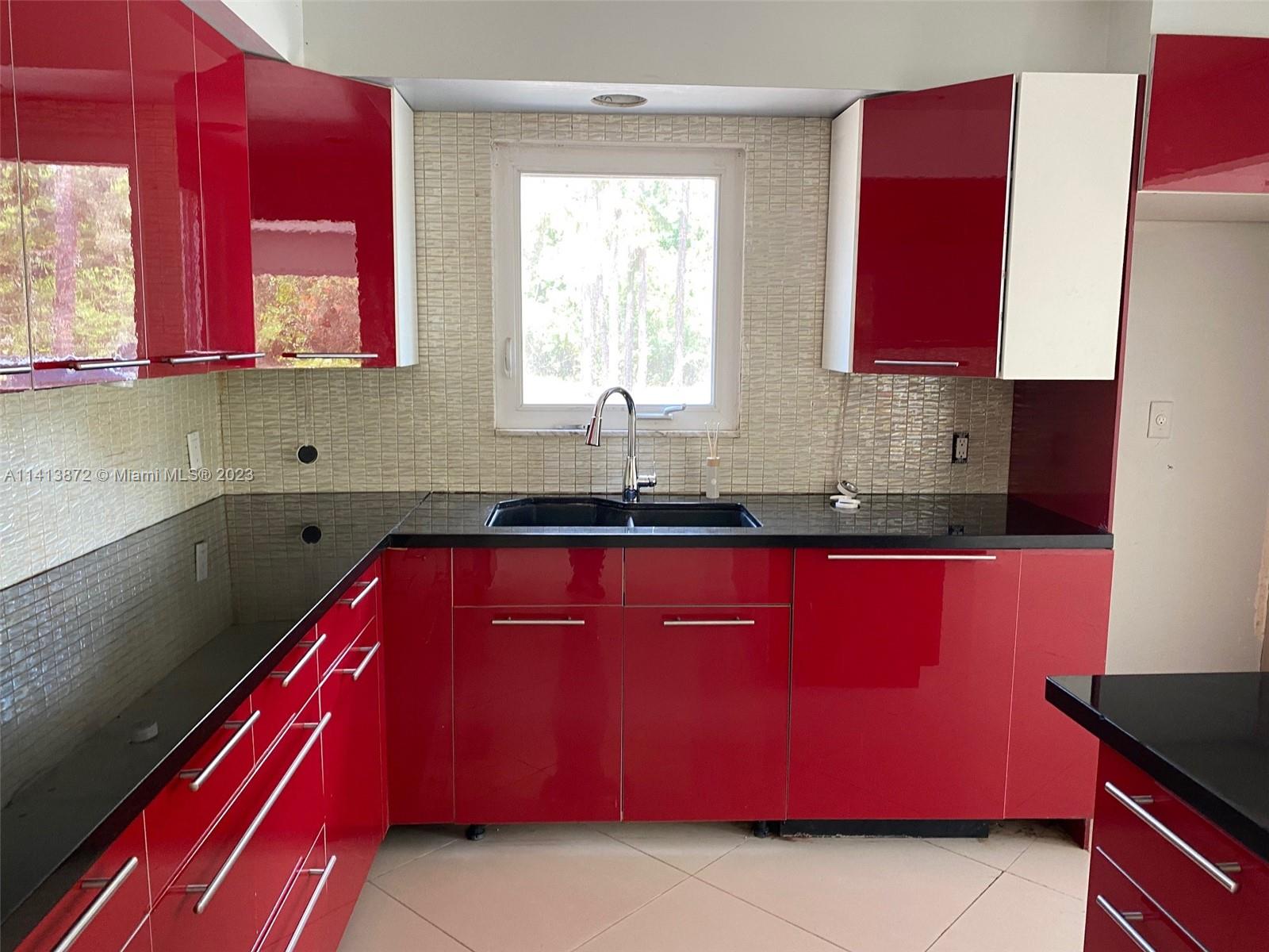 3141 C Road Loxahatchee, FL 33470 - Photo 7 of 16 a kitchen with red cabinets and window
