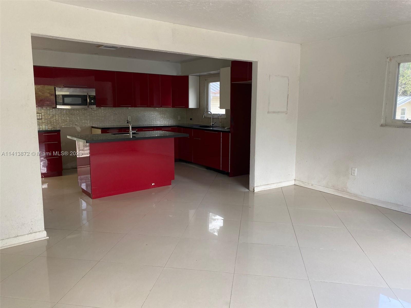 3141 C Road Loxahatchee, FL 33470 - Photo 10 of 16 a kitchen with stainless steel appliances granite countertop a red stove sink and cabinets