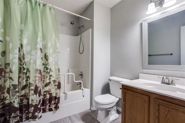 a bathroom with a granite countertop sink toilet and shower