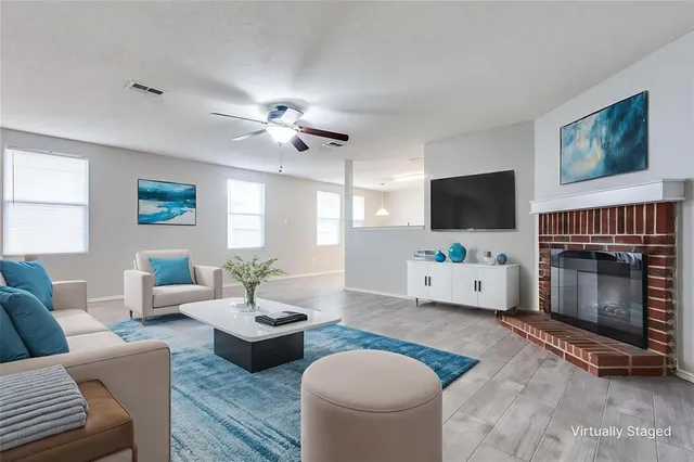 a living room with furniture a fireplace and a flat screen tv