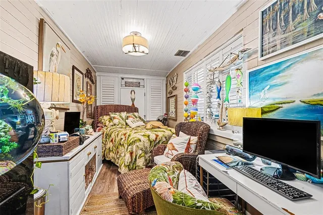 a living room with furniture a flat screen tv and a floor to ceiling window