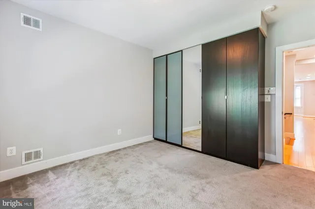 an empty room with closet and mirror