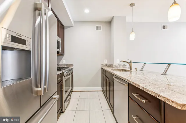 a kitchen with stainless steel appliances granite countertop a refrigerator and a sink