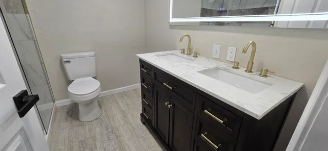 a bathroom with a sink a toilet and a mirror