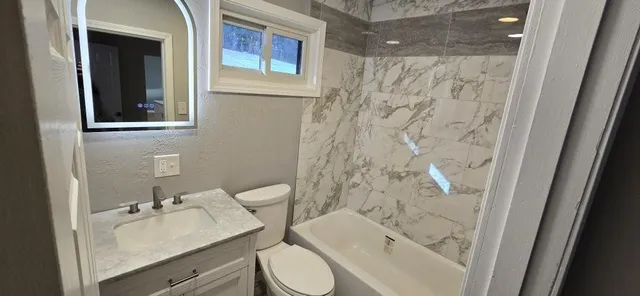a bathroom with a sink toilet and shower