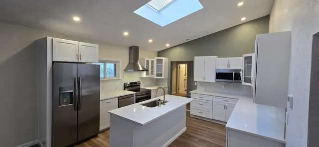 a kitchen with stainless steel appliances a refrigerator sink and microwave