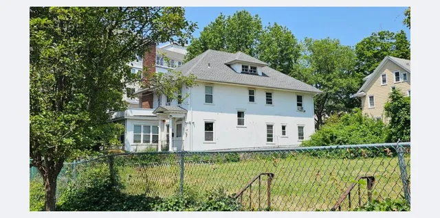 a aerial view of a house with a yard table and chairs