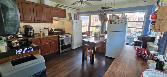 a kitchen with sink a refrigerator and wooden floor