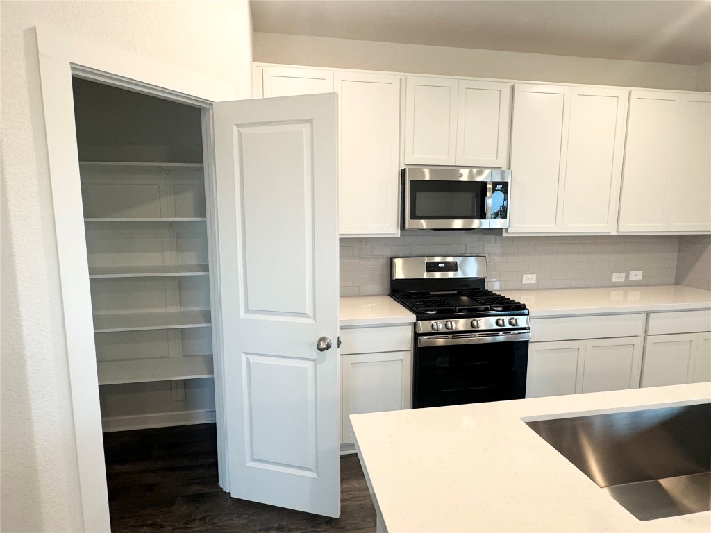 128 Hazy Vw Road San Marcos, TX 78666 - Photo 2 of 22 a kitchen with a refrigerator stove and white cabinets