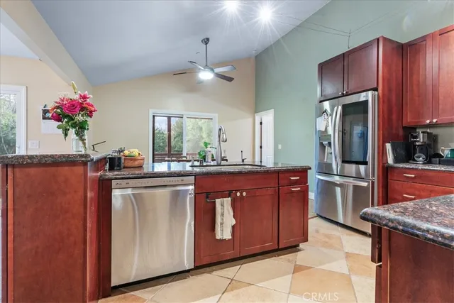 a kitchen with granite countertop a refrigerator and a stove top oven