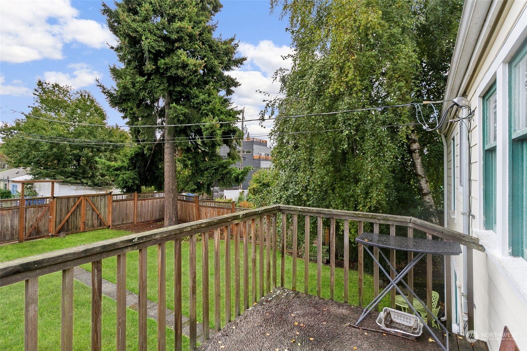 5942 41st Avenue Southwest Seattle, WA 98136 - Photo 36 of 40 a view of a roof deck with wooden fence and trees