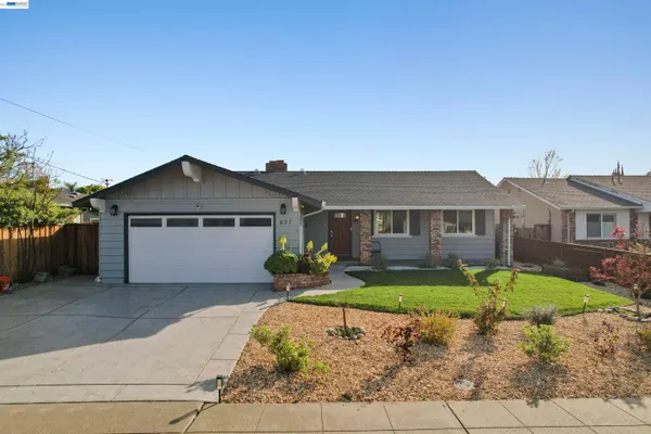 a front view of a house with a yard outdoor seating and garage