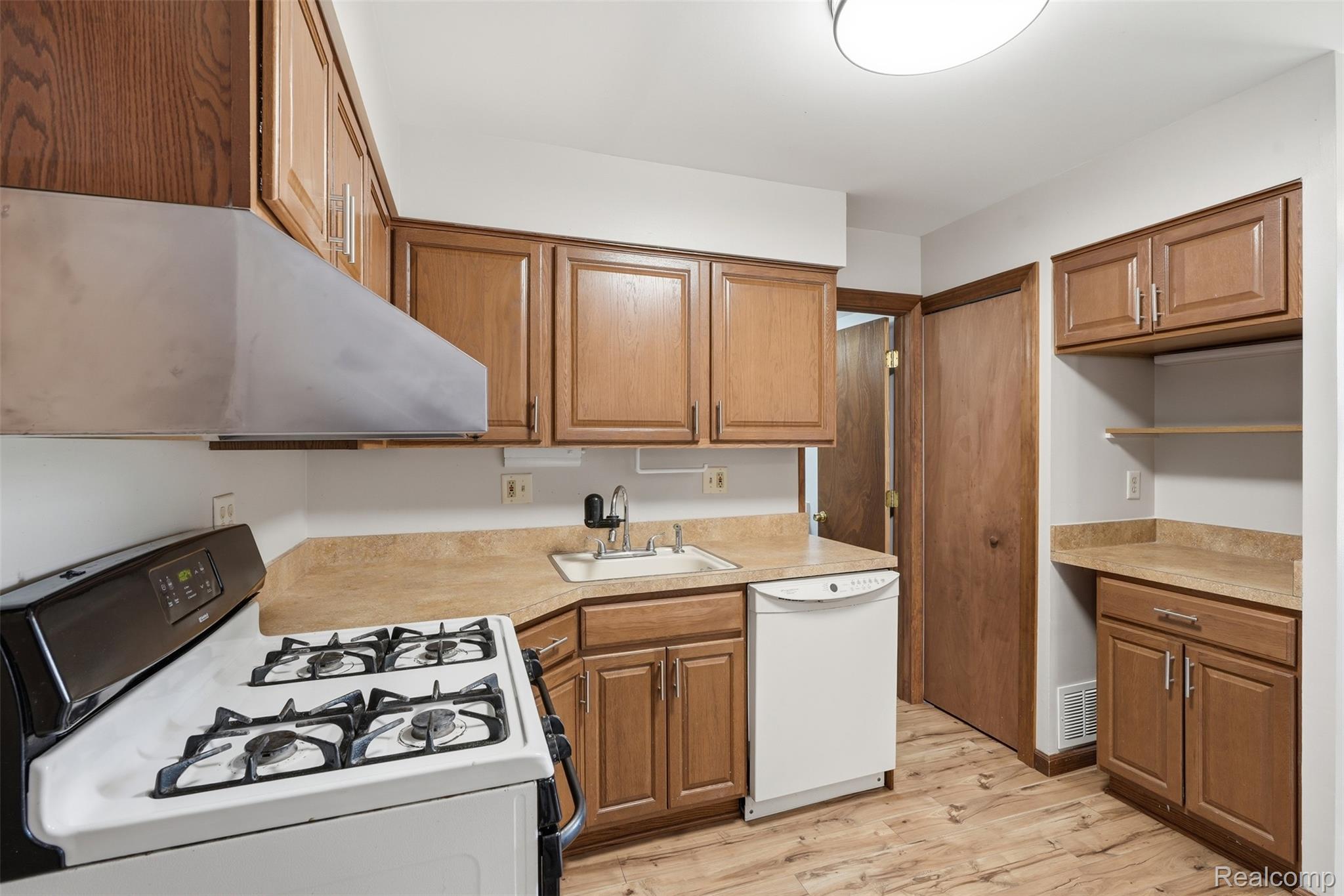 5634 Chicago Road Warren, MI 48092 - Photo 10 of 36 Kitchen featuring wood-finish cabinetry, laminate countertops, and wood-finish flooring