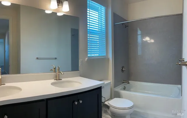 a bathroom with a sink a toilet a shower and a mirror