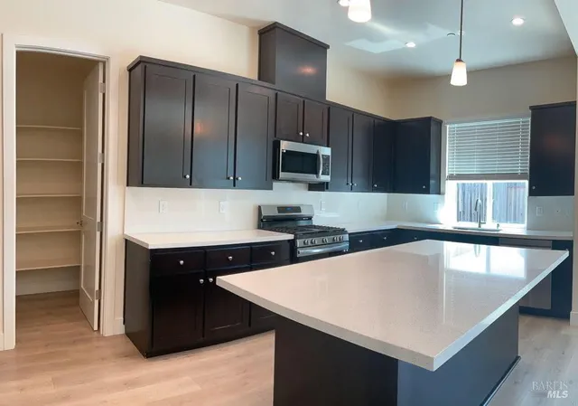 a kitchen with stainless steel appliances granite countertop a sink a stove and a refrigerator