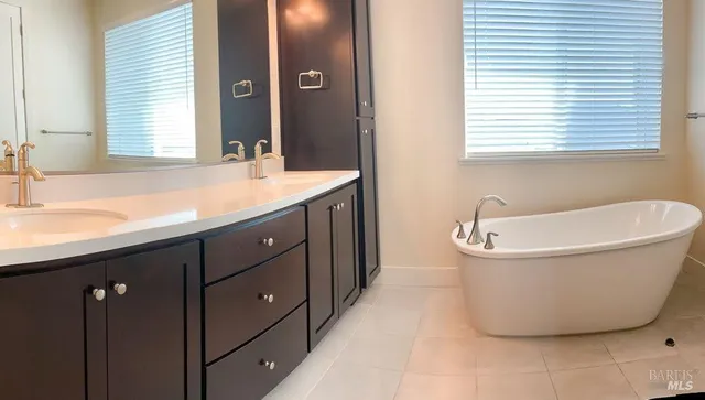 a bathroom with a tub sink and mirror