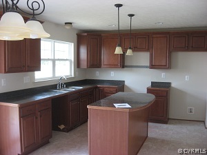 18296 Democracy Avenue Ruther Glen, VA 22546 - Photo 5 of 7 a kitchen with a sink a stove cabinets and wooden floor
