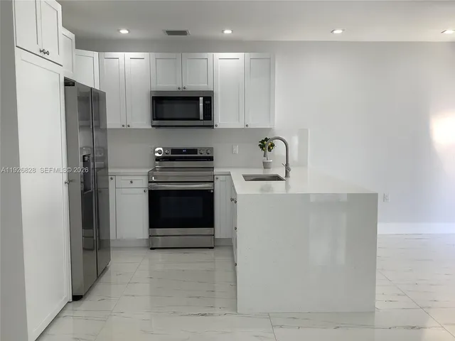 a kitchen with stainless steel appliances a refrigerator stove and microwave
