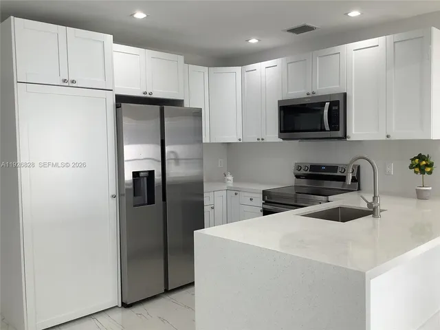 a kitchen with cabinets and stainless steel appliances