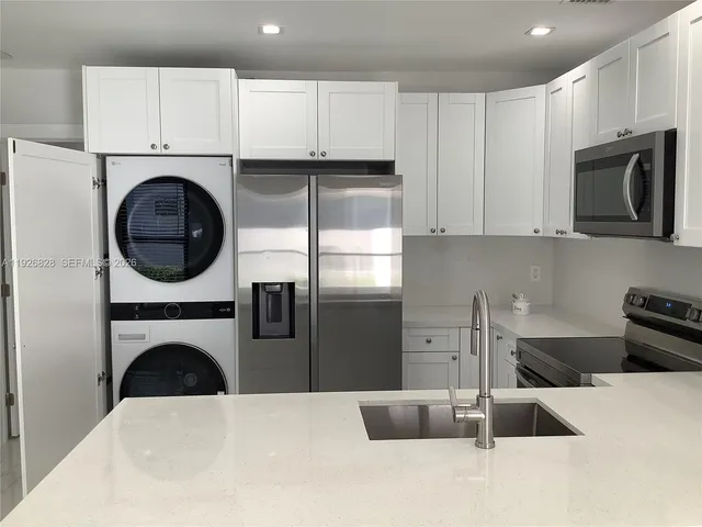 a kitchen with a refrigerator sink and cabinets