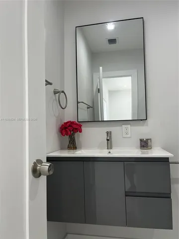 a bathroom with a sink vanity and a mirror