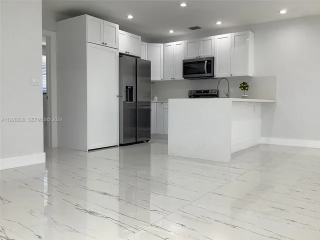 a view of kitchen with stainless steel appliances a refrigerator and a stove top oven